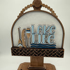 Decorative sign with 'Lake Life' text and paddle design on a white background