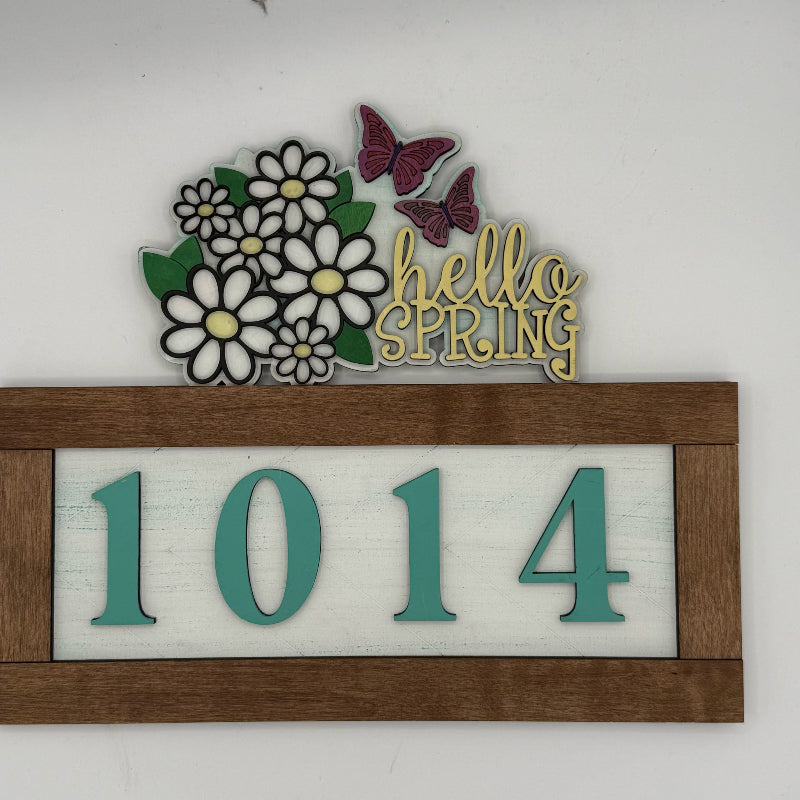 Decorative sign with flowers, butterflies, 'hello spring', and house numbers '1014' on a white background.