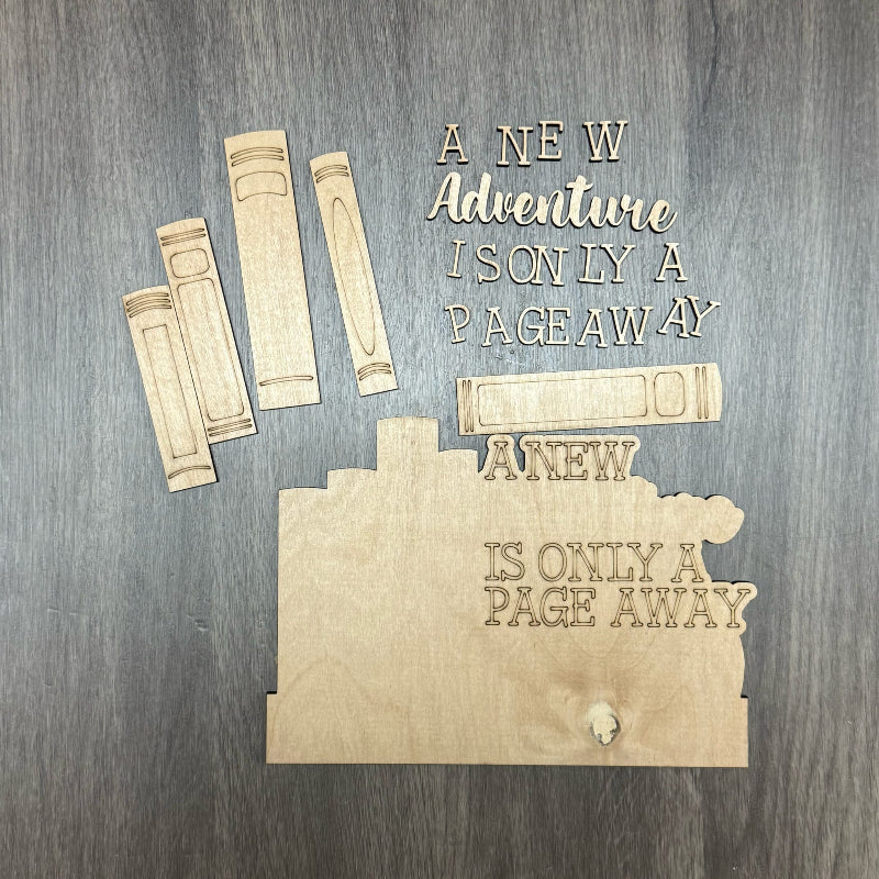 Wooden bookshelf decor with 'A New Adventure Is Only a Page Away' text on a wooden surface.