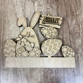 Wooden Easter decorations including a bunny, eggs, and an 'Egg Hunt' sign on a wooden surface.