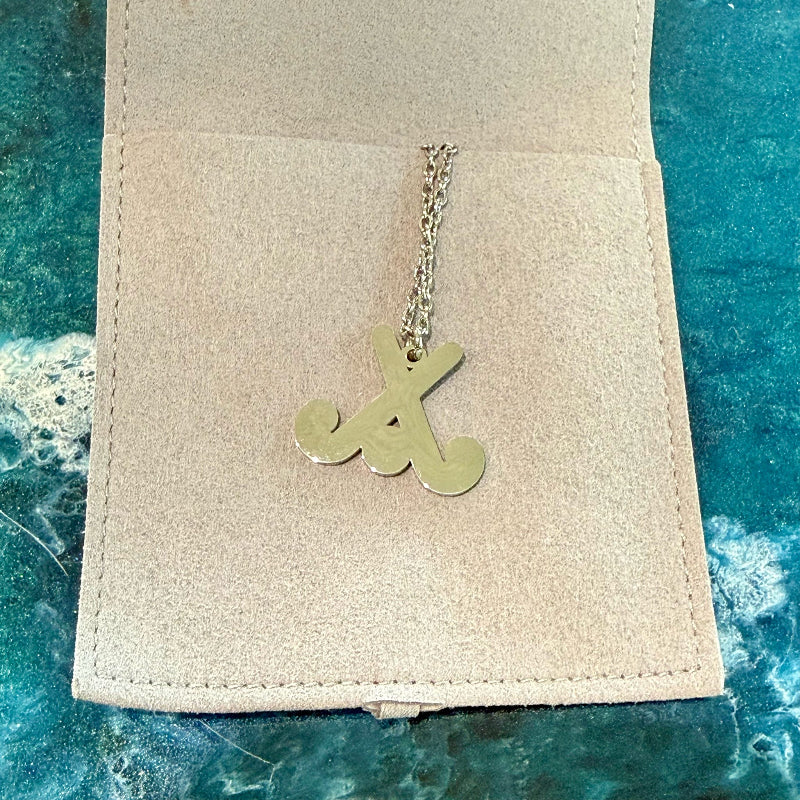 Necklace with a pendant on a beige card against a blue textured background