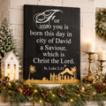 Decorative Christmas mantel with nativity scene, stockings, and Christmas lights.