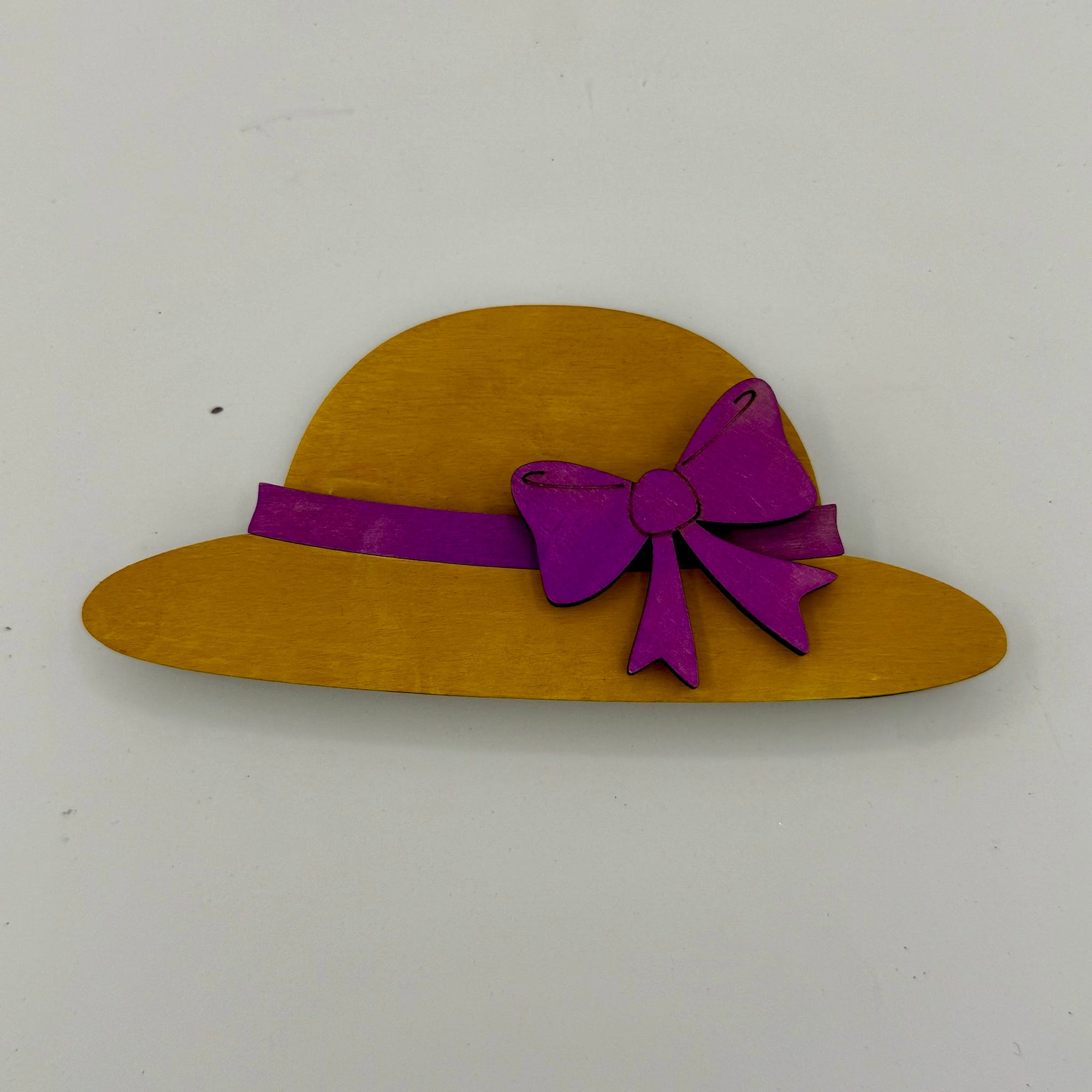 Yellow hat with a purple bow on a white background