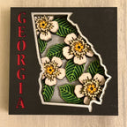 Map of Georgia with dogwood flowers on a wooden background