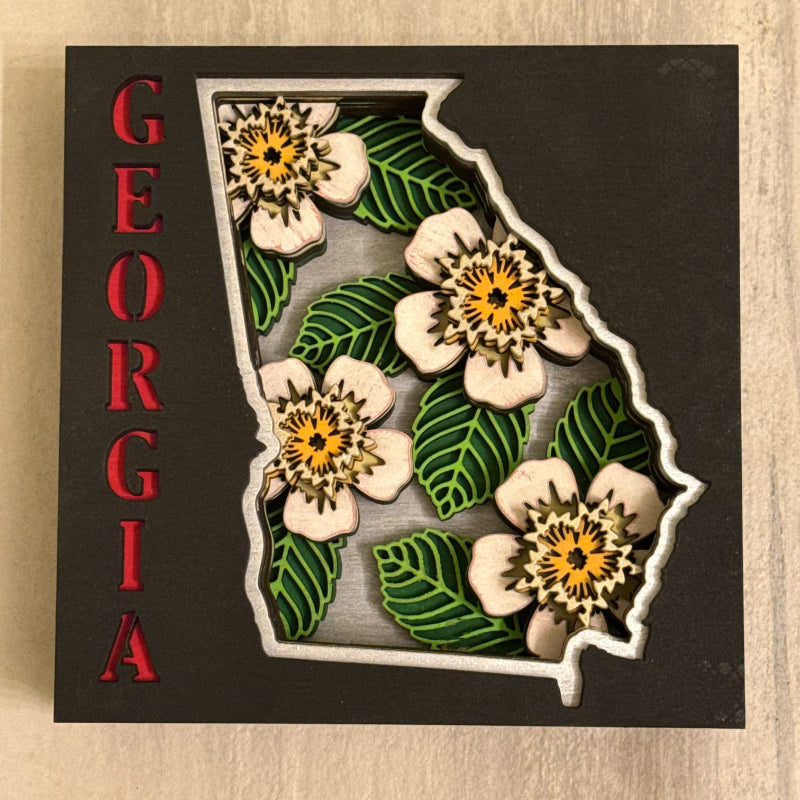 Map of Georgia with dogwood flowers on a wooden background