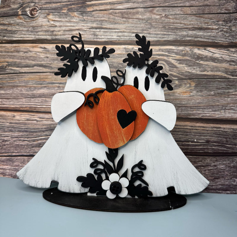 Decorative piece with two white birds holding pumpkins on a wooden background