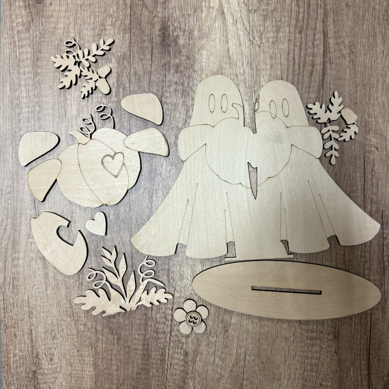 Wooden cutouts of a couple and decorative elements on a wooden surface
