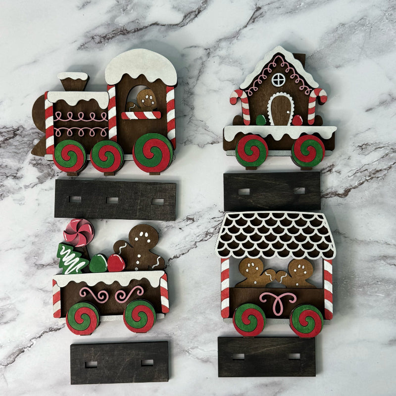 Decorative gingerbread house and train cookies on a marble surface