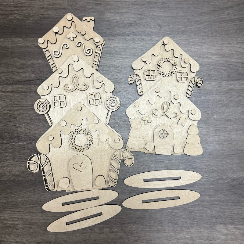 Wooden gingerbread house and tree cutouts on a wooden surface