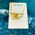 Gold necklace with a heart and shield pendant on a branded card against a blue textured background