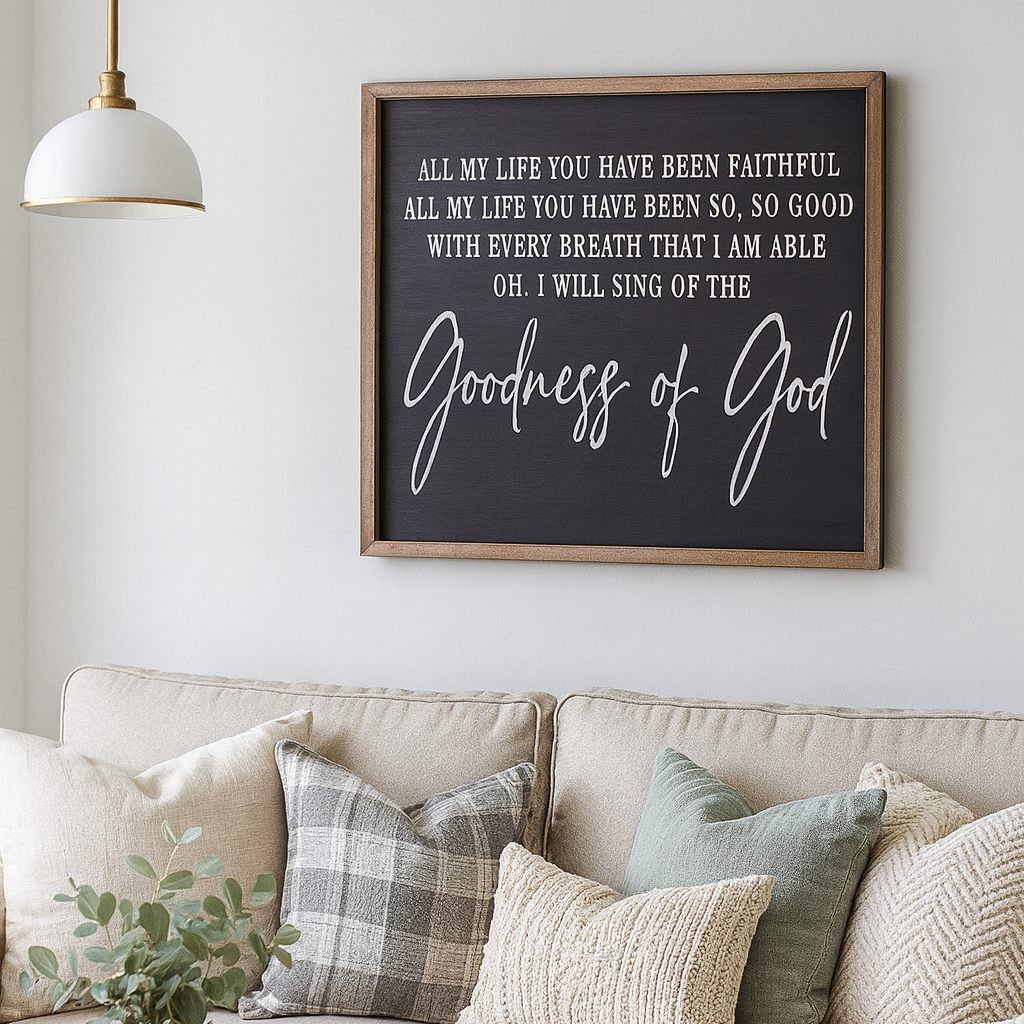 Living room with a beige sofa, decorative pillows, a candle, and a framed Christian quote on the wall.