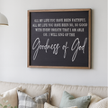 Living room with a beige sofa, decorative pillows, a candle, and a framed Christian quote on the wall.