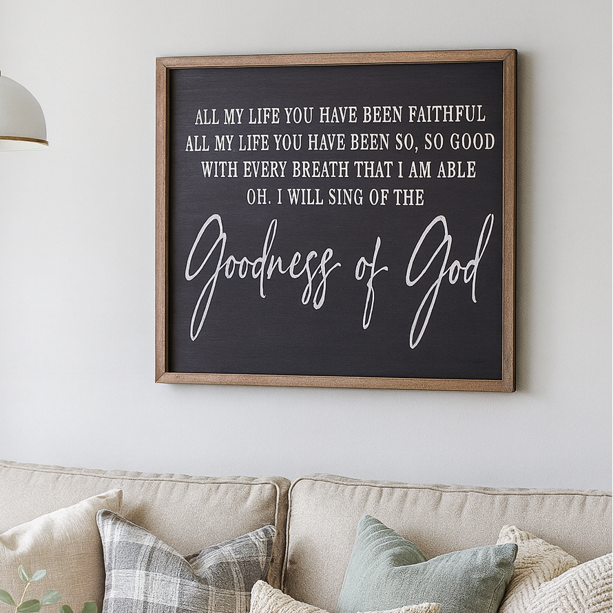Living room with a beige sofa, decorative pillows, a candle, and a framed Christian quote on the wall.