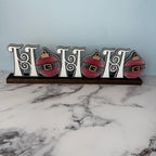 Decorative sign with Christmas ornaments on a marble surface