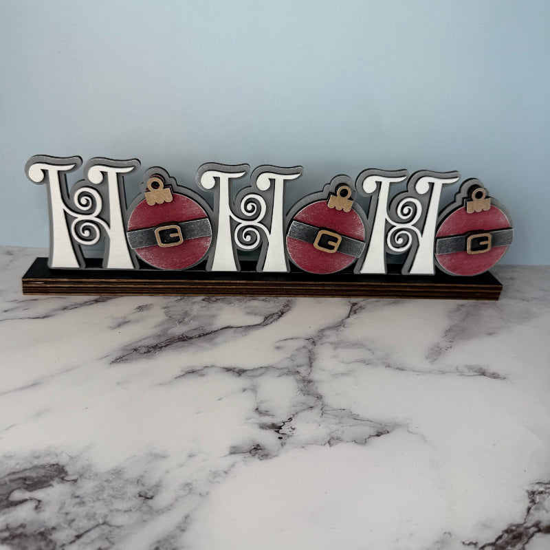 Decorative sign with Christmas ornaments on a marble surface