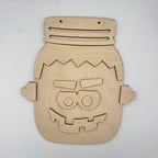 A wooden jigsaw puzzle shaped like a Frankenstein's monster head, made from light natural wood with laser-cut pieces, displayed on a plain off-white background.