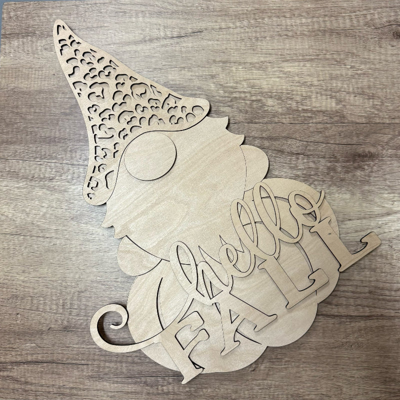 Wooden cutout of a gnome with 'Hello Fall' text on a wooden surface