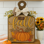 Wooden sign with 'Hello Fall' and pumpkin design on a kitchen counter. DIY Workshop Fernandian Beach, Craft Kit. Fall Craft Kit. 