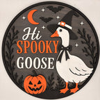 A round Halloween wall sign featuring a white goose wearing a witch hat, orange text reading 'Hi SPOOKY GOOSE,' a jack-o'-lantern, bats, stars, and a crescent moon on a dark gray background.
