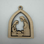 A laser-cut wooden nativity scene ornament featuring Mary, Joseph, and baby Jesus in a stable arch shape, shown on a plain light gray background.