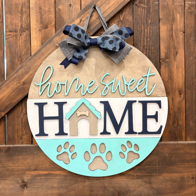 Decorative sign with 'home sweet home' text and paw prints on a wooden background