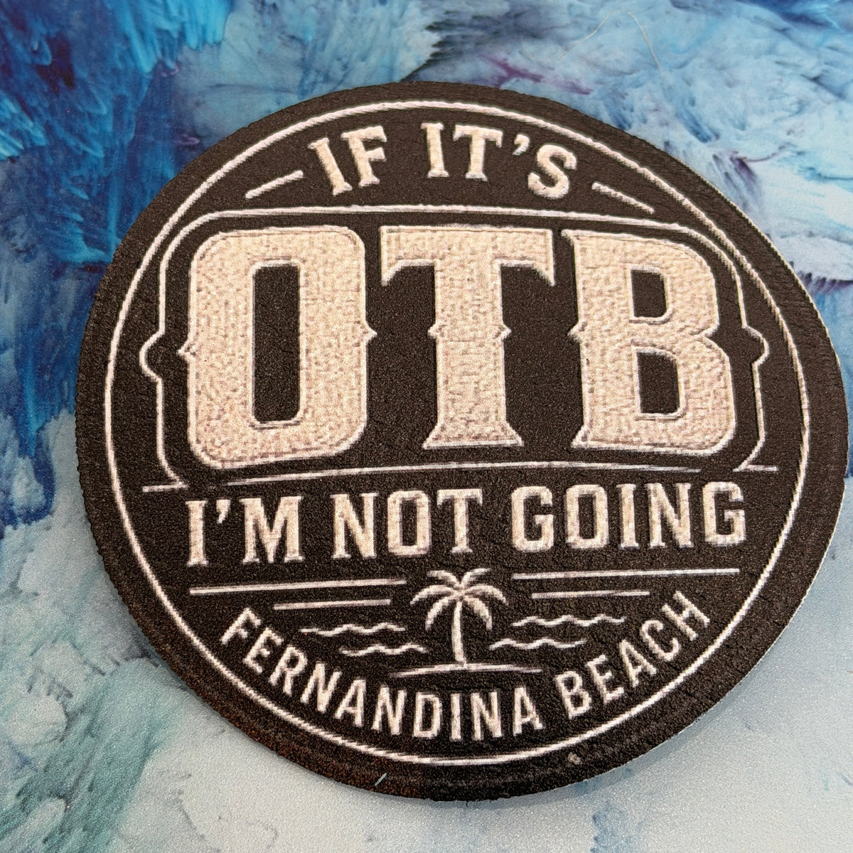 Round sticker with text 'If it's OTRB I'm not going to Fernandina Beach' on a textured blue background