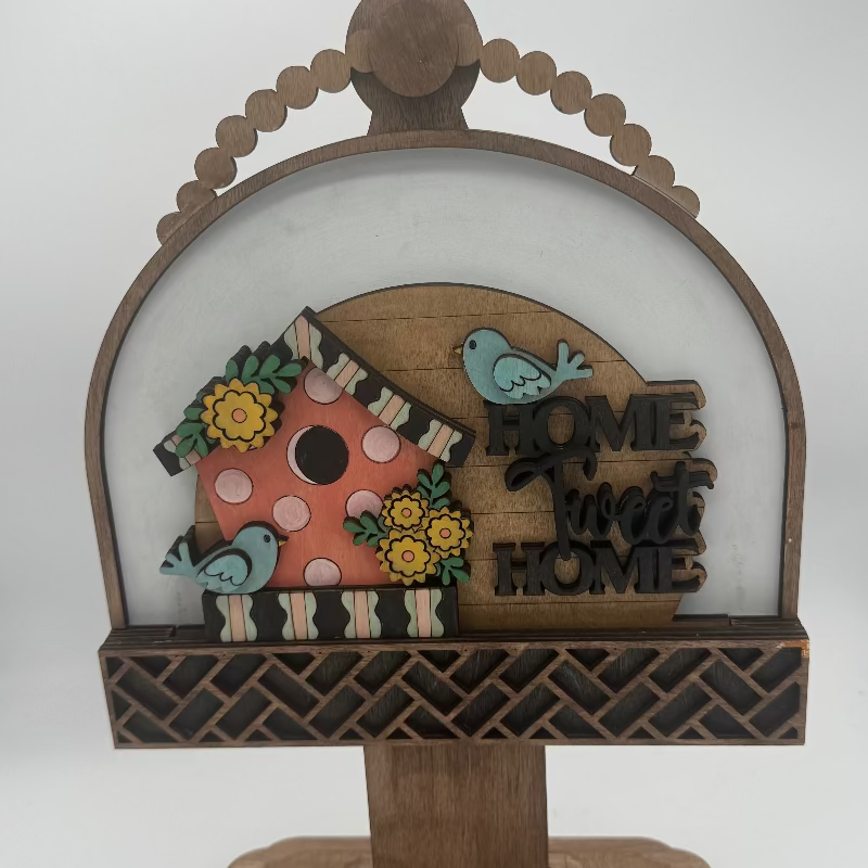Wooden decorative piece with a birdhouse, birds, and 'Home Sweet Home' text on a white background.
