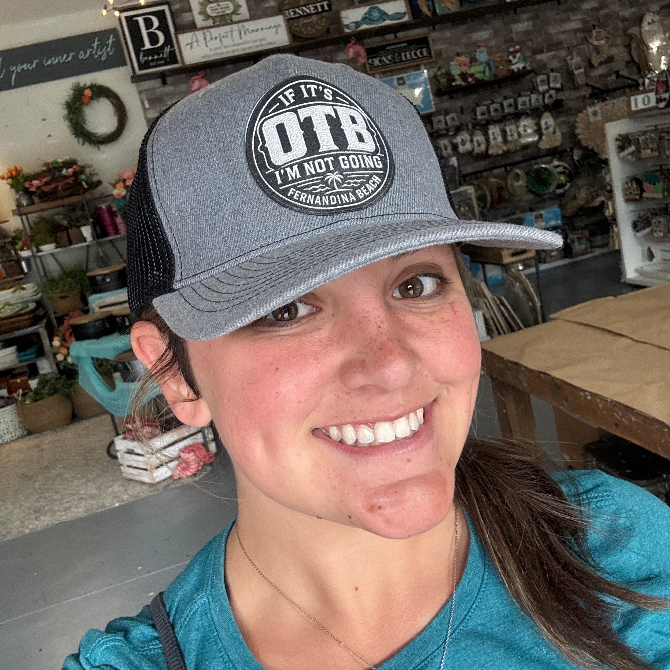 Person wearing a cap with 'If it's OTB I'm not going' text in a store setting