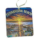 Decorative ornament with 'Fernandina Beach' text and sunset scene on sand and trees background