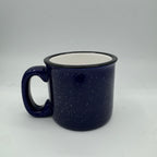 Blue speckled mug with a white interior on a light gray background