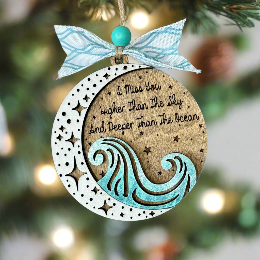 Decorative ornament with wave design and text on a blurred Christmas tree background