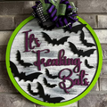 3D door hanger with a green background and bats in black, white text that reads 'It's Freaking Bats'.
