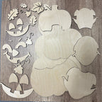 Wooden cutouts of pumpkins and leaves on a wooden background