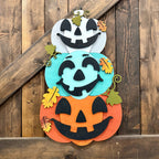 Decorative Halloween sign with jack-o'-lantern faces on a wooden background