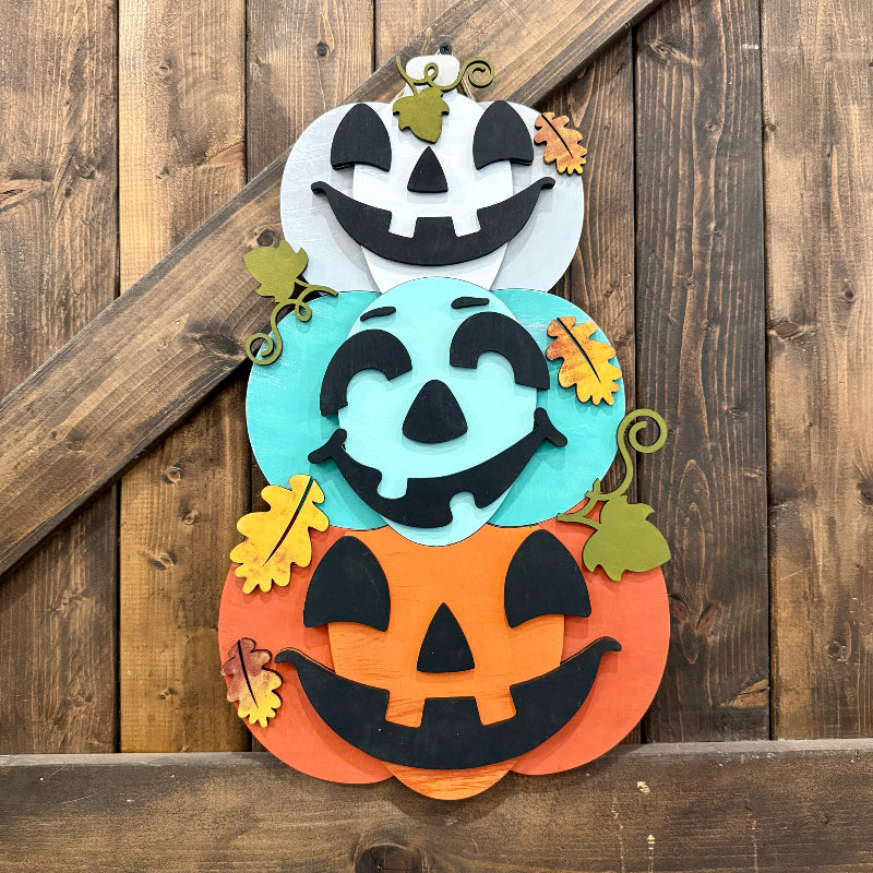 Decorative Halloween sign with jack-o'-lantern faces on a wooden background