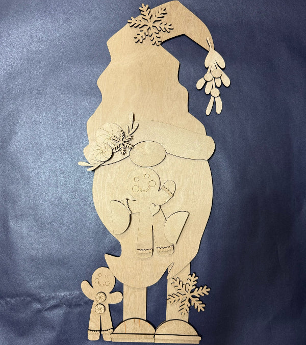 Wooden Christmas decoration with a tall figure, hat, and snowflakes on a blue background