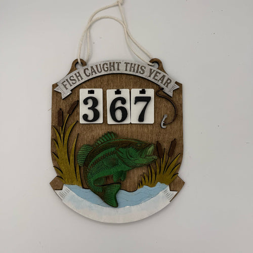 Decorative wall hanging with fish and 'Fish Caught This Year' text on a white background