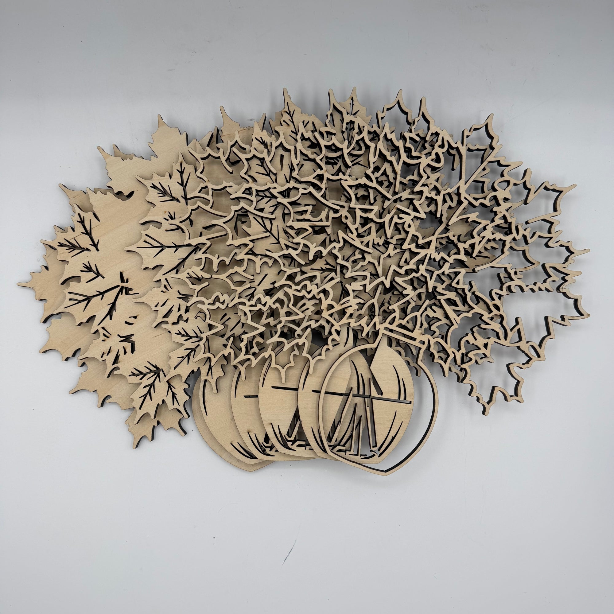 Laser-cut wooden autumn tree and pumpkin craft kit on a light gray background.