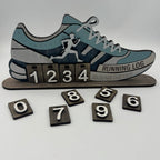 Wooden running log with shoe design and number blocks on a white background