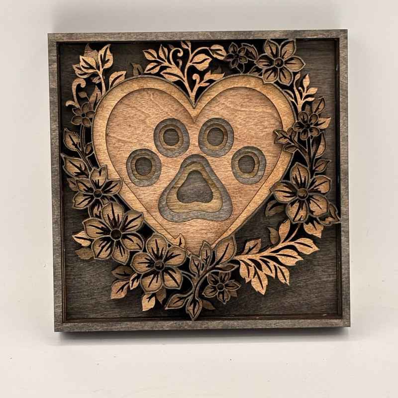 Wooden heart-shaped decoration with paw print design on a white background