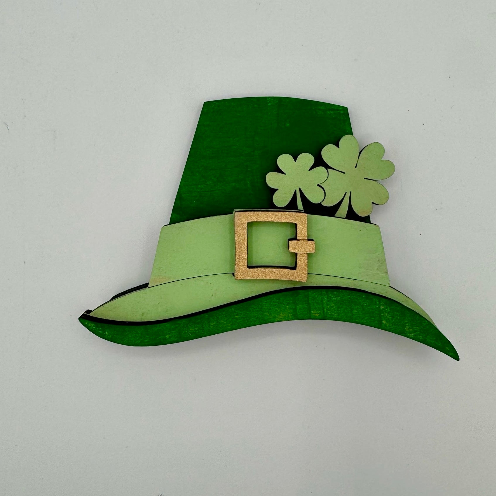 Green leprechaun hat with a buckle and shamrocks on a white background