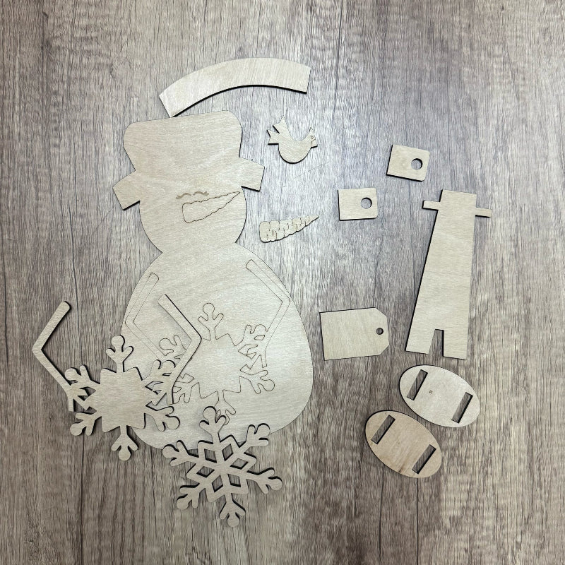 Wooden snowman and snowflake decorations on a wooden surface