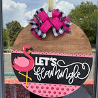 Decorative door hanger with flamingo design and 'Let's Flamingle' text, featuring a large pink bow.