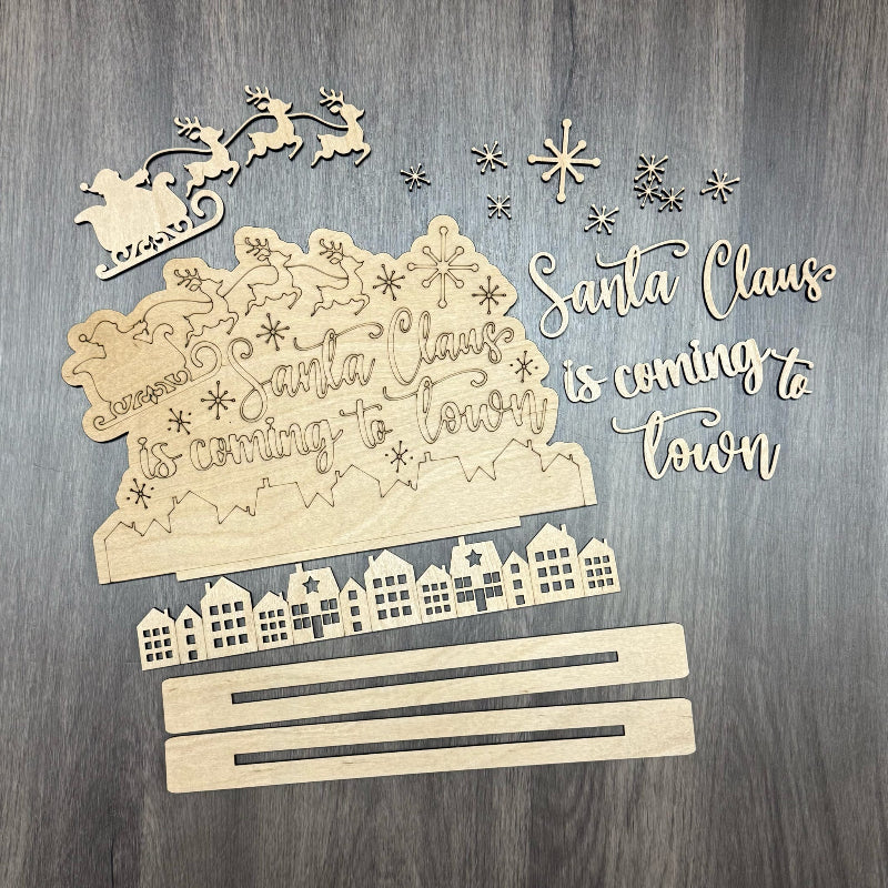 Wooden Christmas decoration with 'Santa Claus is coming to town' text on a wooden background