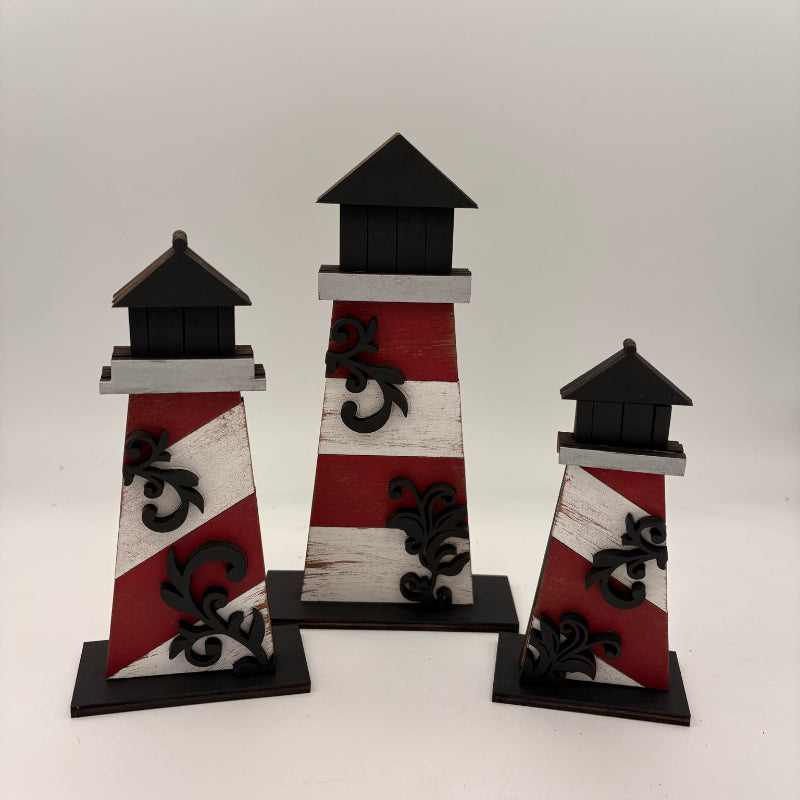Set of three decorative lighthouse figures with red, white, and black design on a white background