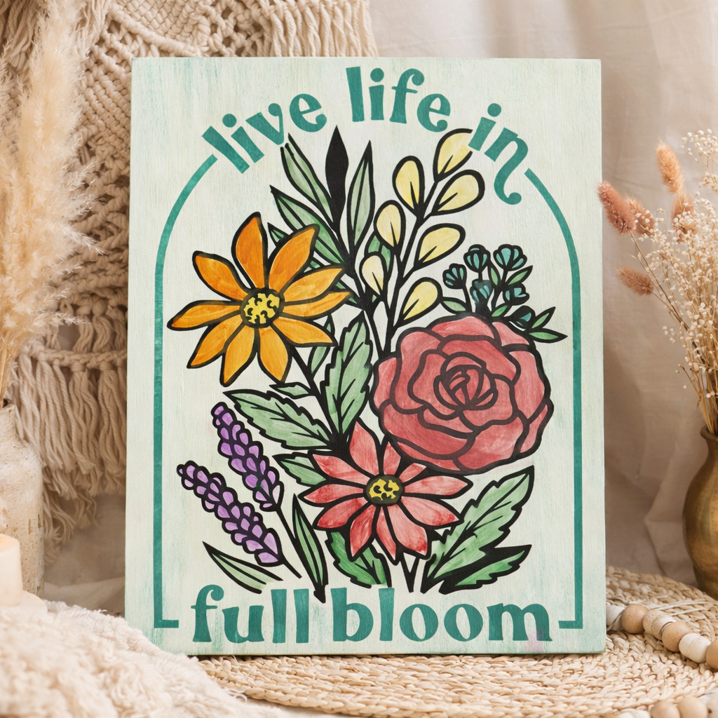 Decorative notebook with floral design and 'live life in full bloom' text, surrounded by decorative elements.