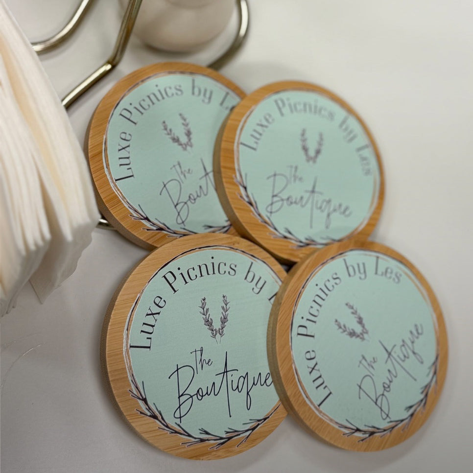 Round coasters with 'Luxe Picnics by Les' branding on a white surface.