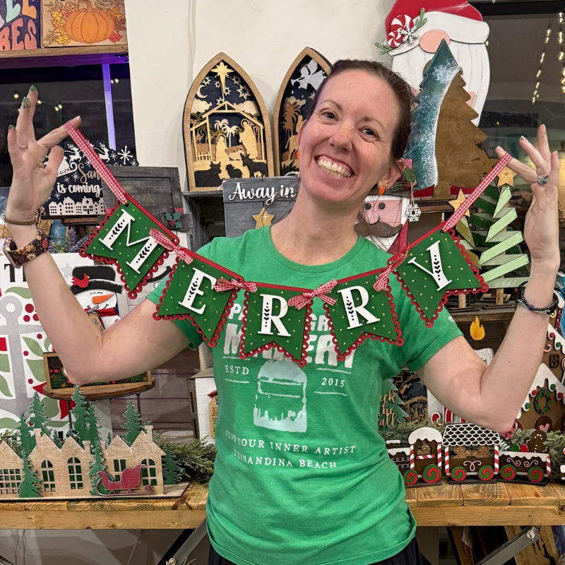 Person wearing a green t-shirt with text, standing in a store with Christmas decorations.