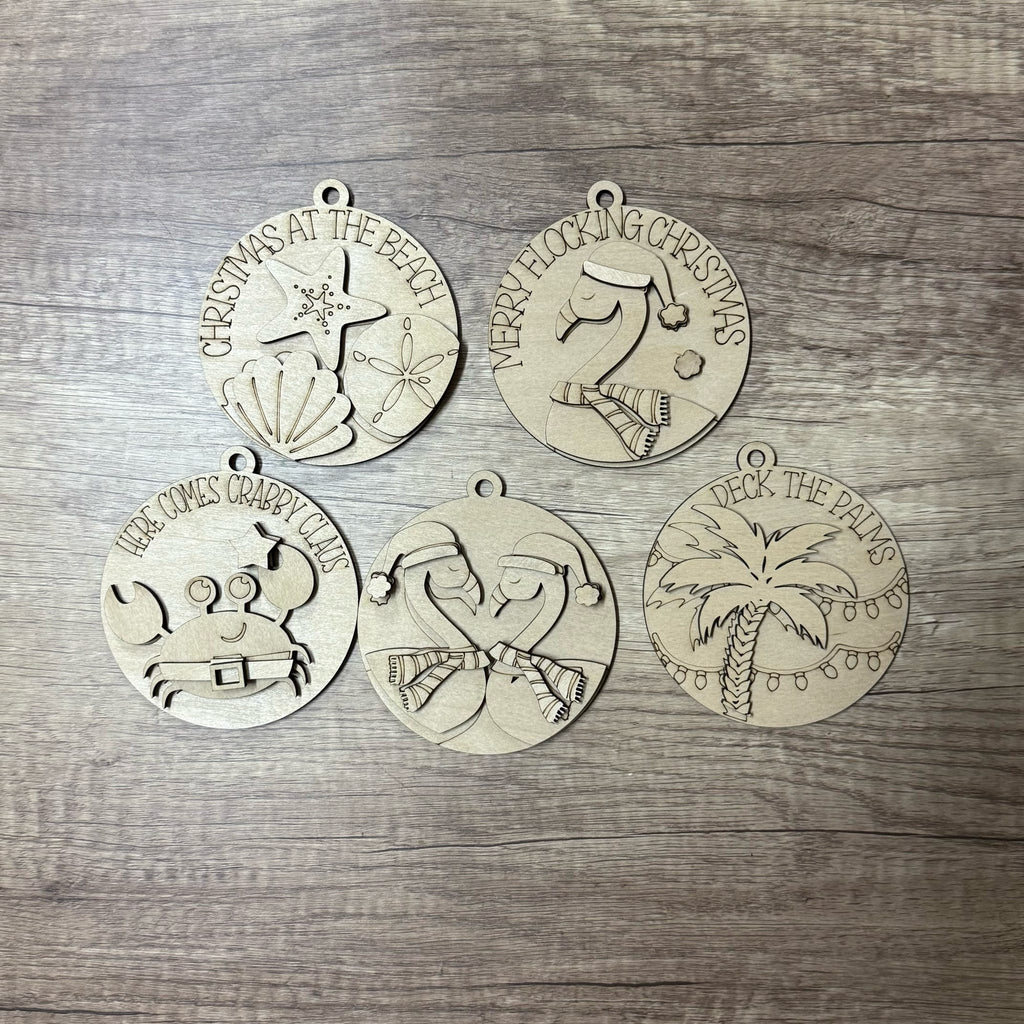 Set of five Christmas-themed metal ornaments on a wooden surface