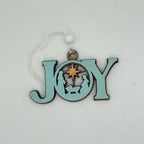 A light blue wooden Christmas ornament spelling out 'JOY' with a Nativity scene cutout in the center, hanging from a white string with a white bead, on a light gray background.